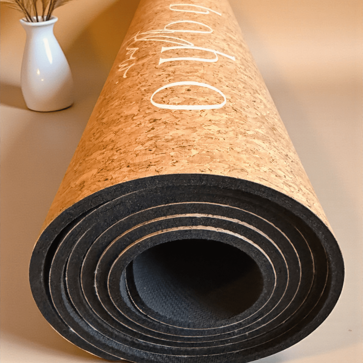 Image shows a very close-up shot of the Boho Flow Aurum Aura Gold cork mat rolled up.