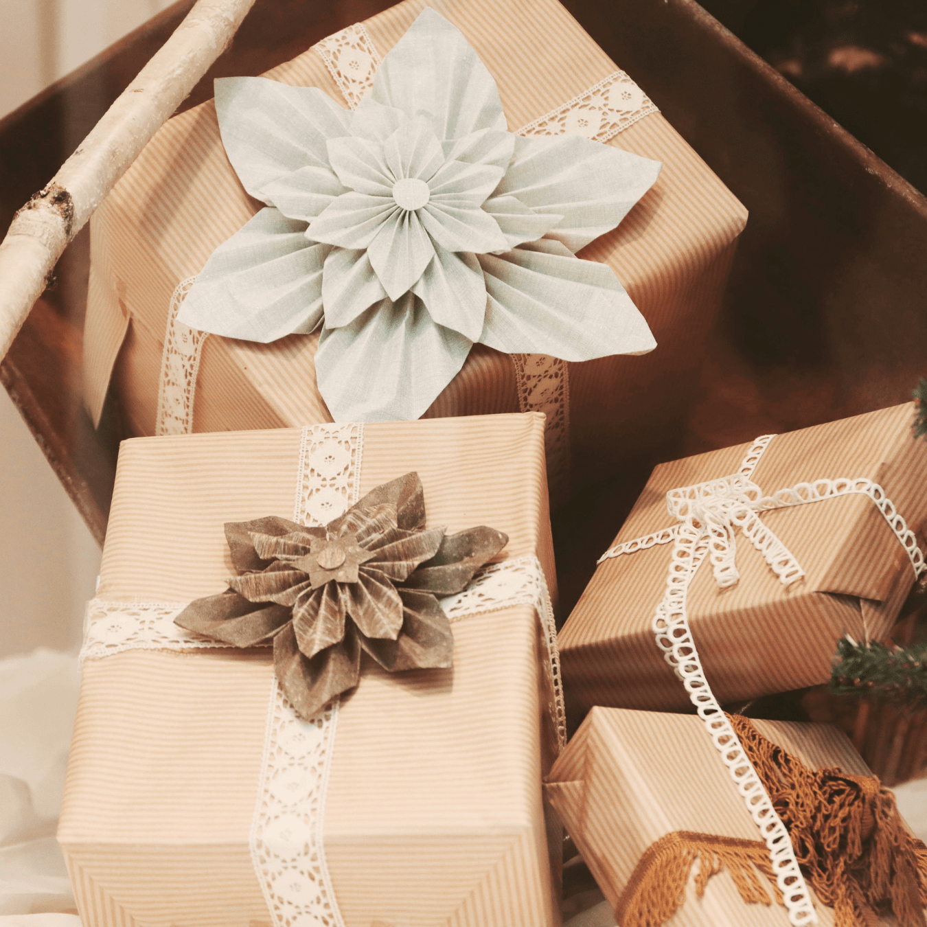 Image shows 4 gift parcels, wrapped in eco-friendly paper with fabric ribbons.