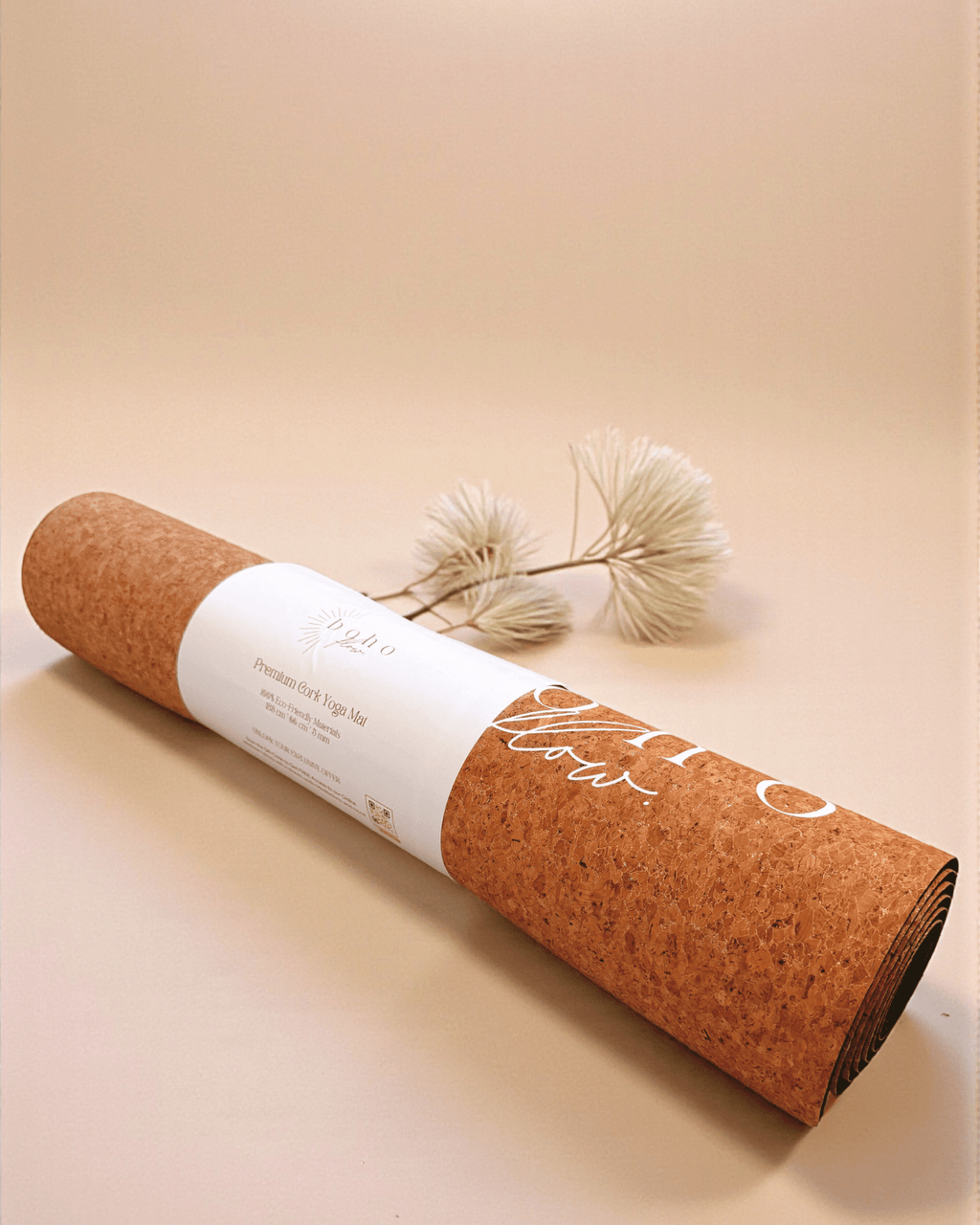 Rolled up cork yoga mat with gold accents on a beige background
