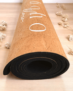 Rolled up vegan leather cork yoga mat on a wooden surface